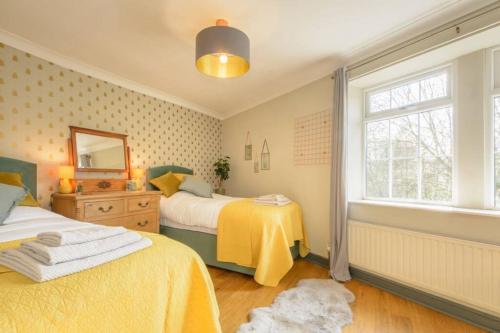 een slaapkamer met 2 bedden en een raam bij Entire cottage in the beautiful Calder Valley in Halifax