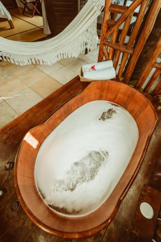 a wooden toilet seat in a room with a hammock at Casa na Praia in Jericoacoara