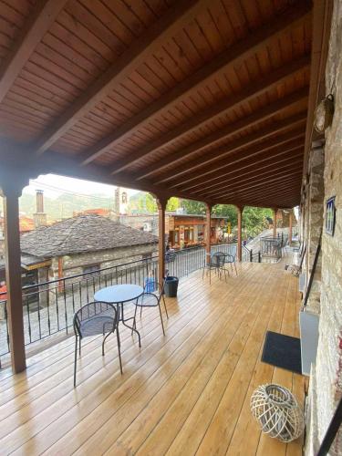 a wooden deck with chairs and tables on a balcony at 11 Luxury Apartments Metsovo in Metsovo