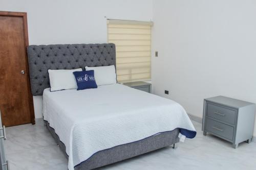 a bedroom with a bed with a blue pillow on it at VILLA COSTA FELIX 1 in Puerto Peñasco