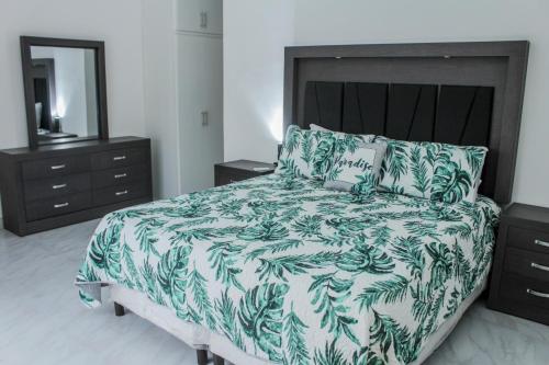 a bedroom with a bed with a green and white blanket at VILLA COSTA FELIX 1 in Puerto Peñasco