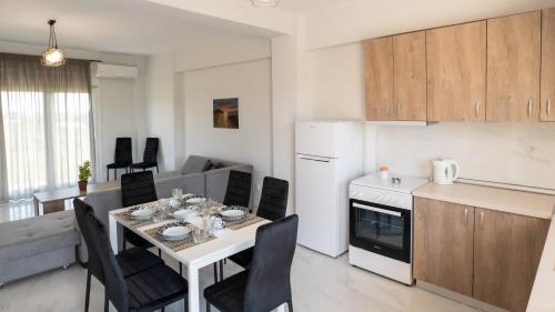 a kitchen and a living room with a table and chairs at Mythic Villas in Epanomi