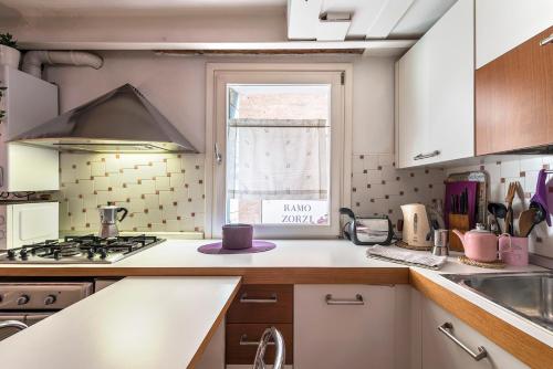 a kitchen with a stove top oven next to a window at PICCOLO - Cozy studio in the heart of authentic Venice in Venice