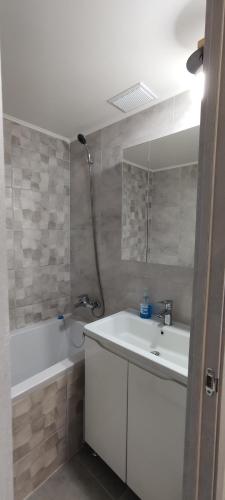 a bathroom with a sink and a bathtub and a sink and a mirror at Victoria in Tiraspol