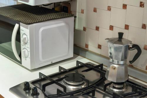 a stove top with a microwave on top of it at PICCOLO - Cozy studio in the heart of authentic Venice in Venice