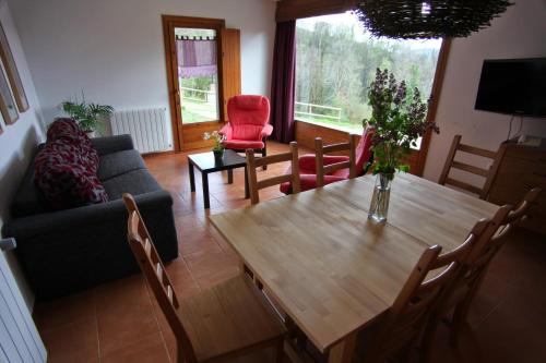 a living room with a wooden table and chairs at Casa Rural "Can Soler de Rocabruna" Camprodon in Rocabruna