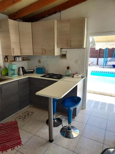 a kitchen with a counter and a table in it at Alekas Pool and Garden Home in Paphos