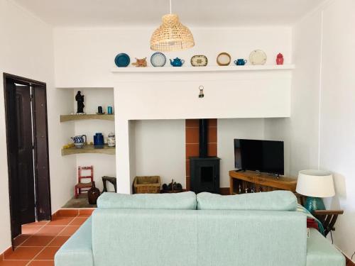 Casa Campinho في Campinho: غرفة معيشة مع أريكة زرقاء ومدفأة