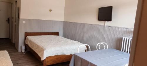 a bedroom with a bed and a tv on the wall at Résidence Les Thermes de Vernet-les-Bains in Vernet-les-Bains
