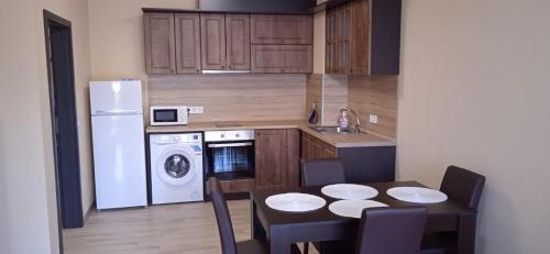Il comprend une petite cuisine avec une table et un réfrigérateur blanc. dans l'établissement Residence Park Sarafovo Apart, à Bourgas
