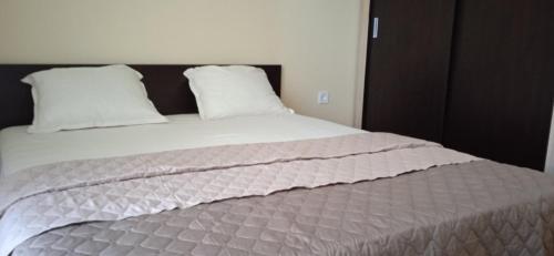 - une chambre dotée d'un grand lit avec des draps et des oreillers blancs dans l'établissement Residence Park Sarafovo Apart, à Bourgas
