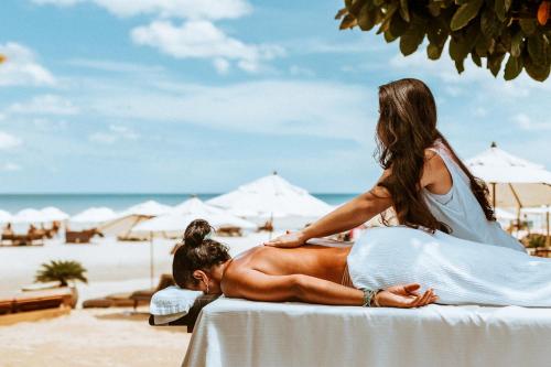 a woman sitting on the back of a man on the beach at Casa na Praia in Jericoacoara