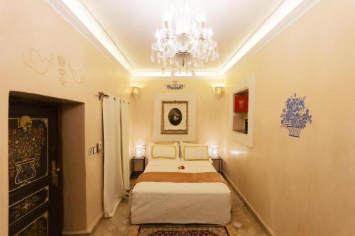 a bedroom with two beds and a chandelier at Riad Palais Des Princesses & Spa in Marrakesh