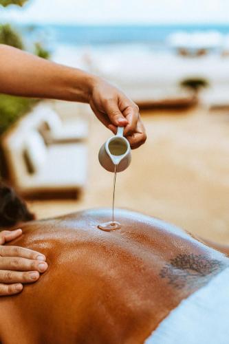 a person is holding a spoon over a persons stomach at Casa na Praia in Jericoacoara