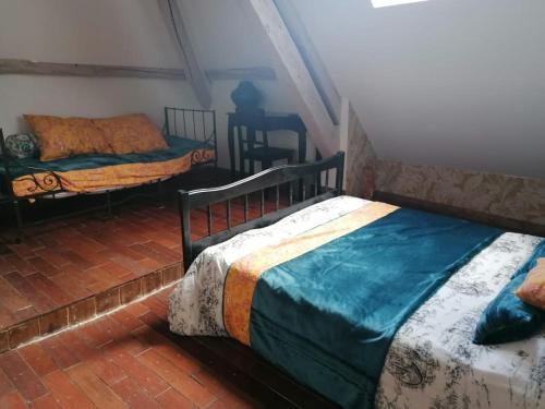 a bedroom with two beds and a table in it at Hôtellerie Jardiniers Gourmands in Morsains