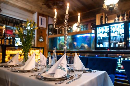 a table with glasses and napkins on it in a restaurant at Apartamenty Kapitańskie - Pływające in Oława