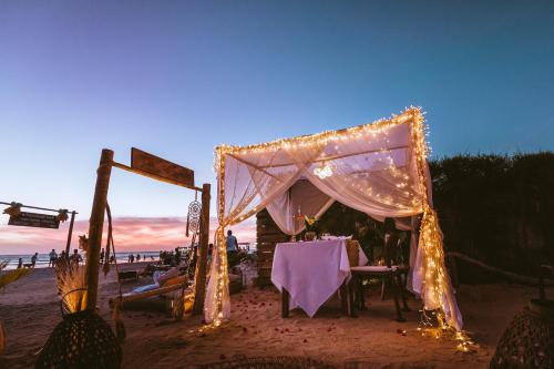 a tent with a table and chairs on the beach at Casa na Praia in Jericoacoara