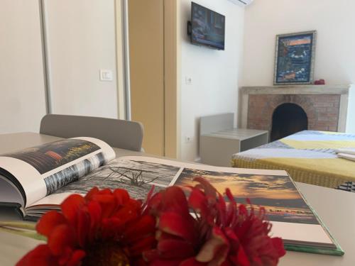 a table with a book and a flower on it at Affittacamere Stella di Mare in Levanto