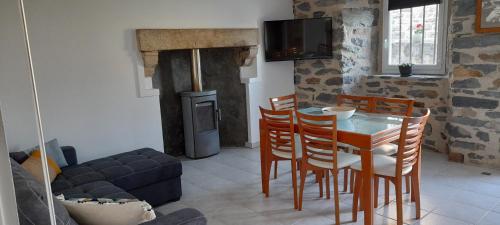 un salon avec une table, des chaises et un canapé dans l'établissement Chez Nave au pied du Meygal, à Boussoulet