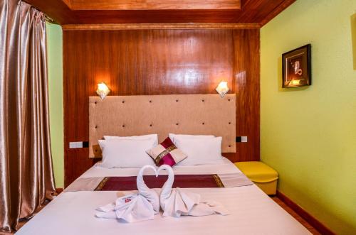 a hotel room with two beds with towels on them at Summer Villa Guest House in Maafushi