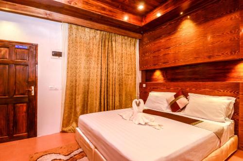 a bedroom with a bed with a towel on it at Summer Villa Guest House in Maafushi