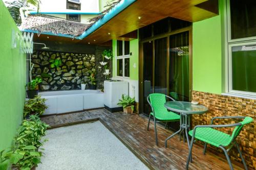 a patio with a table and chairs and a tub at Summer Villa Guest House in Maafushi