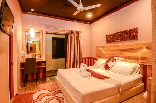 a bedroom with a bed and a bathroom at Summer Villa Guest House in Maafushi