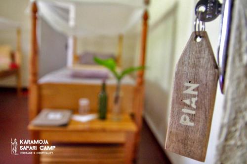 a sign hanging on a door of a bedroom at Kara-Tunga Safari Camp in Moroto
