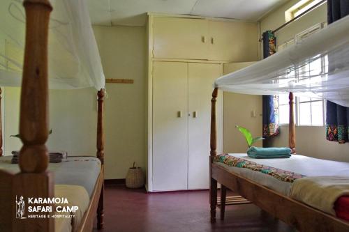 a bedroom with two beds and a closet at Kara-Tunga Safari Camp in Moroto