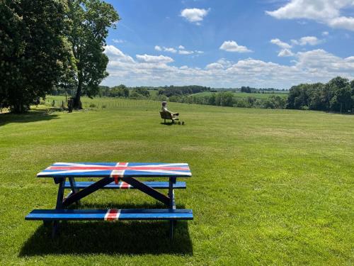 a picnic table with an american flag on it in a field at Fawlty Fields in Aynho