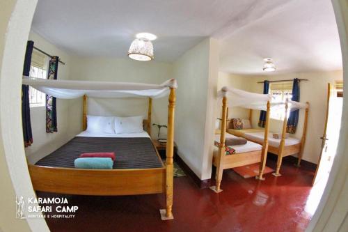 a bedroom with two bunk beds in a room at Kara-Tunga Safari Camp in Moroto