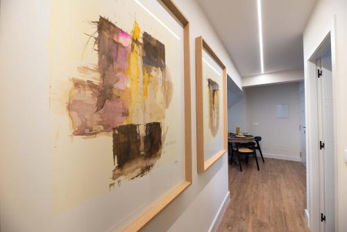 a hallway with paintings hanging on a wall at LA CASITA DE FINA in Caldas de Reis