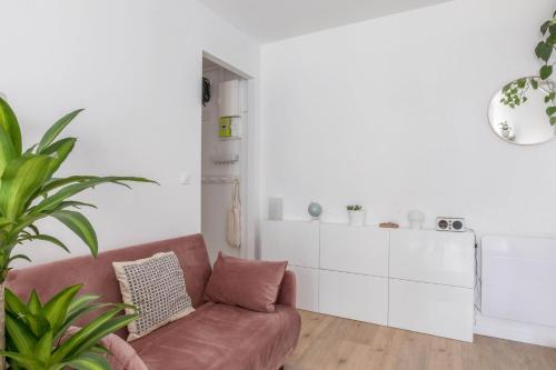 - un salon avec un canapé et une armoire blanche dans l'établissement Appartement Dorian - Welkeys, à Paris