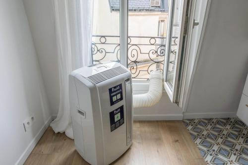 Cette chambre dispose d'un radiateur en face d'une fenêtre. dans l'établissement Appartement Dorian - Welkeys, à Paris