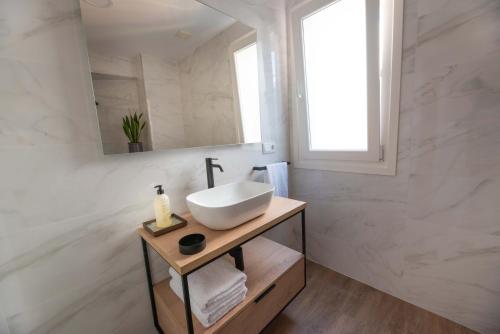 a white bathroom with a sink and a mirror at LA CASITA DE FINA in Caldas de Reis