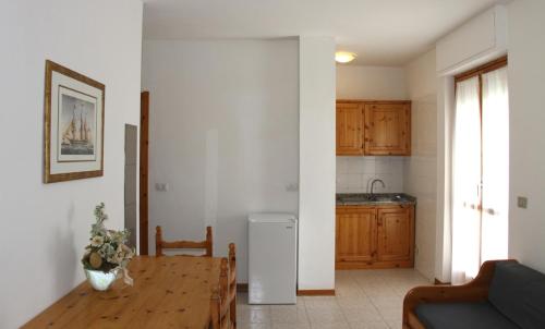 ein Wohnzimmer mit einem Tisch und einer Küche in der Unterkunft Gardenia Casa Vacanze in Alghero
