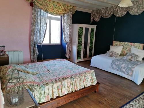 a bedroom with two beds and a window at Hôtellerie Jardiniers Gourmands in Morsains
