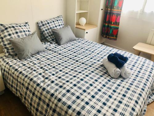 - une chambre avec un lit revêtu de draps bleus et blancs dans l'établissement L'athlétique - 033, à Rouen