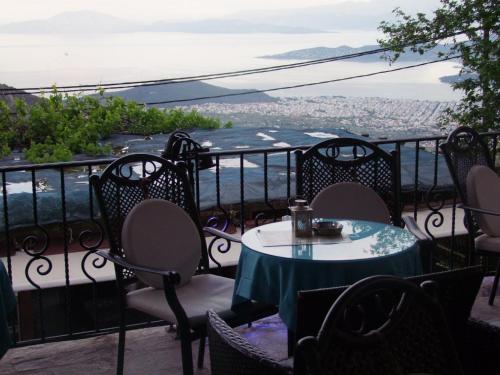 a table and chairs on a balcony with a view at Mansion Theodora in Makrinítsa