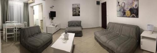 a living room with two chairs and a couch and a table at Apartmani Matković in Sutomore