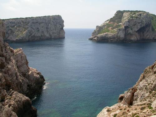 a view of the ocean between two rocky cliffs at Gardenia Casa Vacanze in Alghero