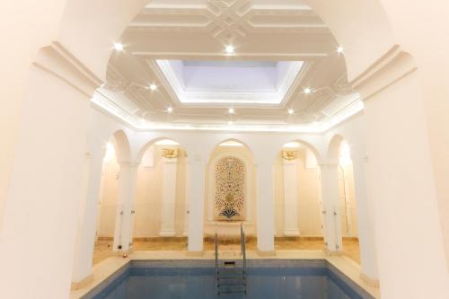 a large room with a ceiling and a pool at Riad Palais Des Princesses & Spa in Marrakesh