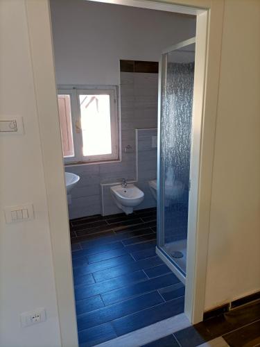 a bathroom with a shower and a sink and a toilet at Appartamenti Alpino in Baselga di Pinè