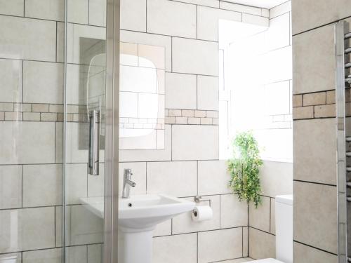 a bathroom with a sink and a shower at Bodlasan Groes Cottage in Holyhead