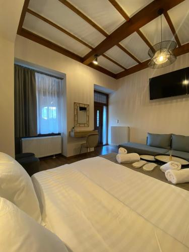 - une chambre avec un grand lit blanc et un canapé dans l'établissement 11 Luxury Apartments Metsovo., à Metsovo