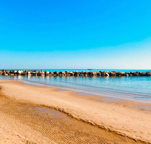 uma praia com um grupo de pedras na água em Kennedy Apartment em Termoli