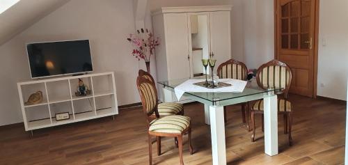 a dining room with a glass table and chairs at Apartament Melania in Sarnowy