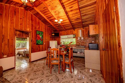 una cucina con pareti in legno, tavolo e sedie di Cabañas La Pradera a Monteverde Costa Rica