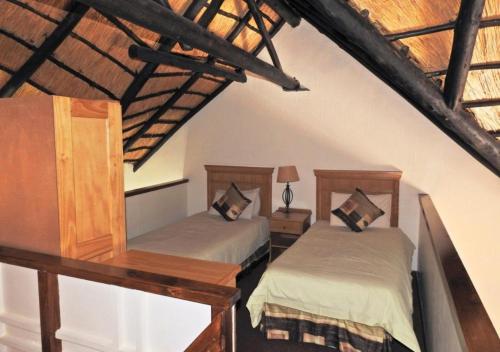 a bedroom with two beds in a attic at Fairways Holiday Accommodation in Drakensberg Garden