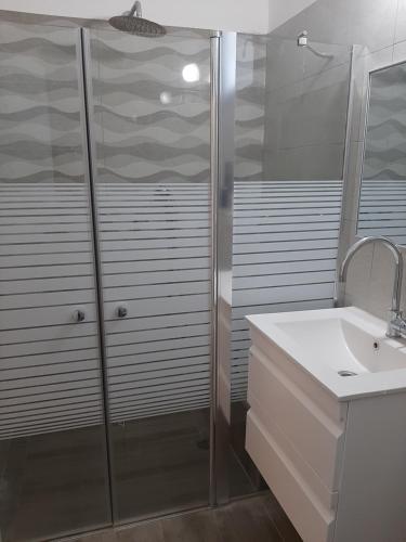 a white bathroom with a shower and a sink at רוח ברמה in Bruchim Qela' Alon